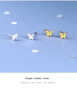 Macro view of minimalist S925 sterling silver butterfly stud earrings in gold and silver