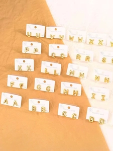 Detailed grid of gold-plated stainless steel alphabet earrings with polished finish