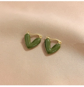 Detail of V-shaped dark green enamel earrings with polished gold metal hoops