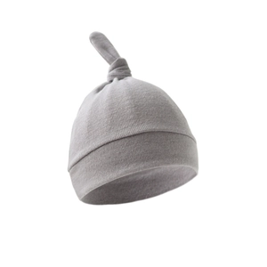 Close-up of a soft grey knotted newborn baby hat in premium cotton knit fabric