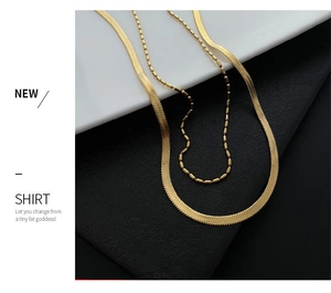 Detail of layered gold titanium necklace featuring flat snake chain and beaded link design