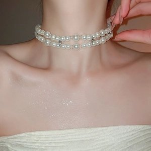 Close-up of elegant double-layered pearl necklace with crystal beads on neck