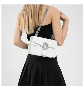 Detail of white crocodile pattern shoulder bag with silver chain and diamond buckle