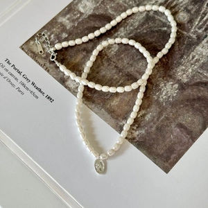 Detail of 925 sterling silver lobster clasp and oval queen pendant on pearl necklace