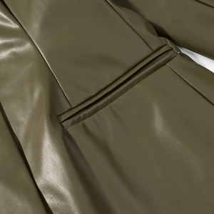 Detailed close-up of olive green PU leather texture and precise pocket stitching on jacket