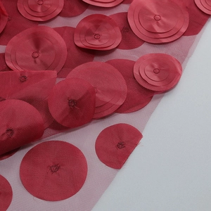 Detail of red 3D floral appliques on mesh fabric for a formal evening dress