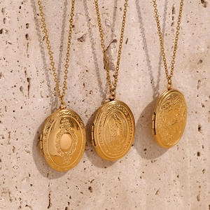 Vertical macro view of three 18K gold-plated oval locket necklaces with floral engravings