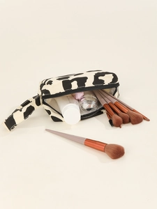 Detail of cow print canvas makeup bag showing spacious interior with brushes and bottles