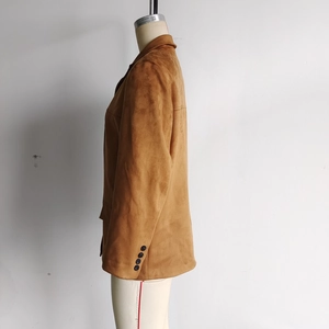 Detail view of camel suede jacket sleeves showing multiple buttons and premium texture