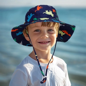 Close-up of kids dinosaur sun hat with wide brim and adjustable toggle on beach