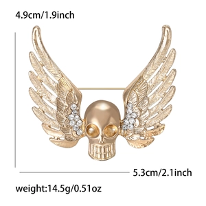 Punk style skull brooch with gold wings and rhinestones measuring 4.9cm by 5.3cm