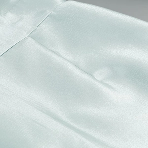 Close-up of light blue shiny fabric with lantern sleeve texture and fine stitching