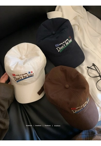 Three vintage cotton baseball caps in white, blue and brown with letter embroidery detail
