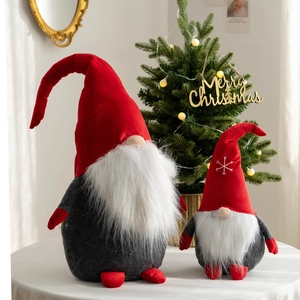 Set of two red and grey Christmas Gnomes with white beards on a festive tabletop