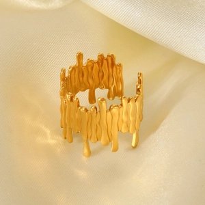 Detailed view of irregular 18K gold plated molten ring on white silk background