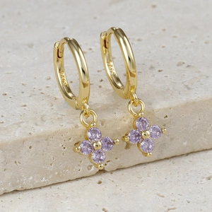 Detail view of gold hoop earrings with purple flower zircon petals and S925 hallmark