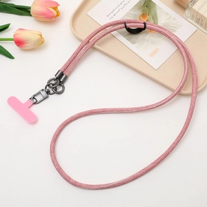 Pink glitter denim crossbody phone lanyard with metallic hardware on a beige tray