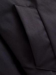 Close-up detail of high-density black twill fabric and folded pocket construction on jacket