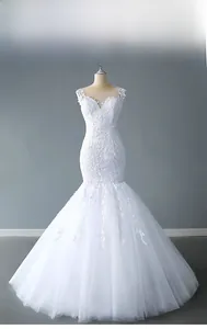 Close-up of intricate lace embroidery and sheer V-neckline on a white mermaid wedding dress
