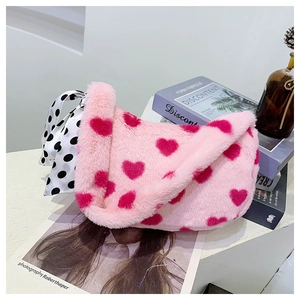 Detail of pink plush heart shoulder bag with decorative polka dot scarf and soft texture