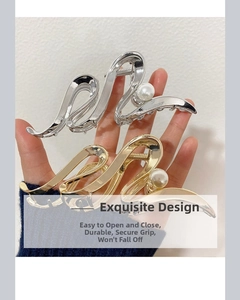 Detail view of gold and silver wavy metal hair claws with elegant pearl accents