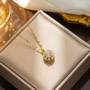 Rotating heart petal pendant necklace in gold finish with blue and clear zircon crystals
