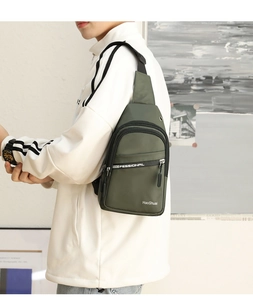 Army green nylon chest bag worn by a model in sporty white jacket outdoor