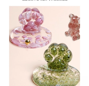 Detail of cartoon paw phone stand made with pink natural crystal and clear resin