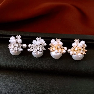 Detailed view of 18K gold and silver plated pearl earrings with sparkling zircon crystals