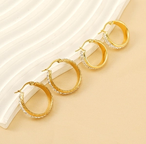 Detail view of gold-plated hoop earrings with sparkling crystal-inlaid pavé setting