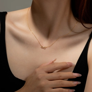 Elegant gold infinity symbol necklace with pavé zircons on model neck and collarbone