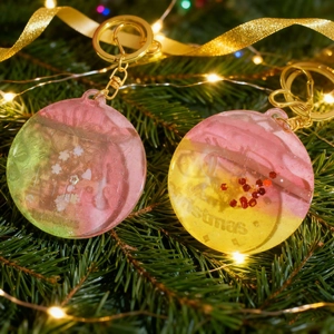 Detalle macro de colgantes navideños de resina con letras de Merry Christmas en relieve