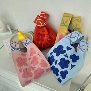 Detail of colorful floral knit tote bags featuring vibrant patterns and soft textures