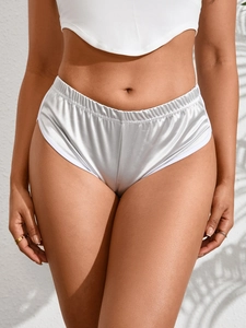 Dettaglio degli shorts da yoga argento metallizzato con bordo bianco ed elastico