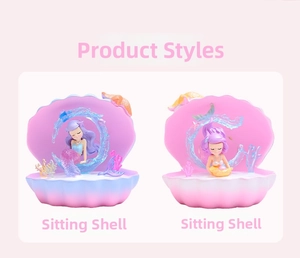 Detail view of two mermaid figurine pen holders in pink and blue seashell bases