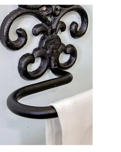 Macro detail of European vintage cast iron fleur-de-lis towel holder with matte black finish