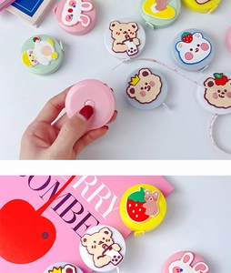 Close-up of cute cartoon plush measuring tape being pulled out from a colorful mini set