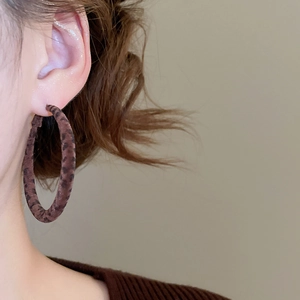 Gros plan d'une boucle d'oreille créole floquée léopard portée pour un style vintage