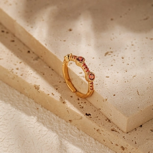 Close-up of vintage 18K gold plated ring with red zircon stones on a stone base