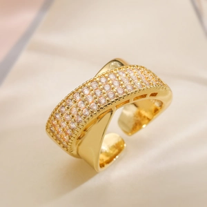 Elegant two-tone gold plated open ring with pavé cubic zirconia on a soft beige fabric
