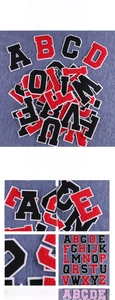 Macro detail of red and black chenille letter patches with thick white borders on denim
