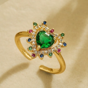 Macro shot of 18K gold plated heart ring with a large green gem and multi-color stones