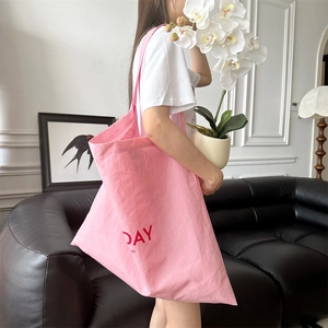 Detailed view of pink canvas tote bag with red DAY lettering print and spacious capacity