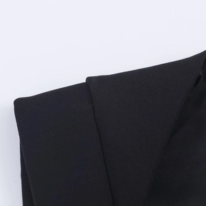 Close-up of premium black twill fabric texture and collar detail of a chic romper