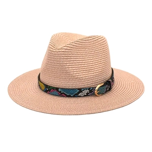 Close-up of light brown straw fedora with colorful snakeskin band and gold buckle detail