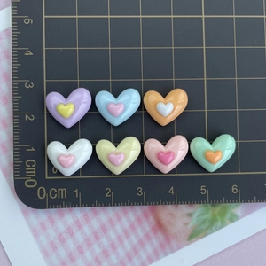 Detailansicht bunter Herz-Harzanhänger auf einer Schneidematte für DIY-Handwerk