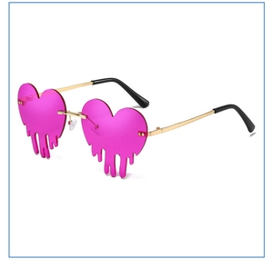 Detailed view of heart-shaped melting lava sunglasses with pink lenses and gold metal temples