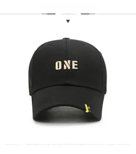 Detail of black baseball cap featuring gold ONE embroidery and color stitching on the brim