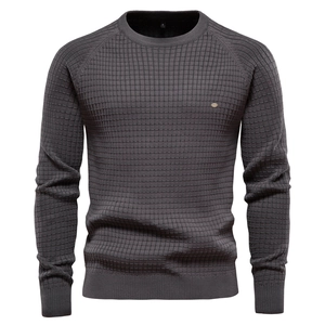 Détail de la texture gaufrée grise et du col rond sur un pull à manches longues