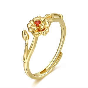 Macro detail of adjustable gold flower ring with red zircon stone and botanical branch